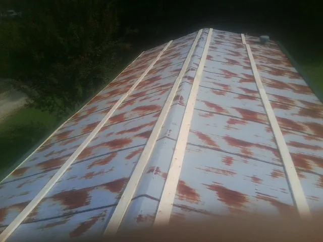 Rusted metal roof panels with new wood purlins before replacement — Storm Damage Roof Repair in Towanda by Roofing Brothers