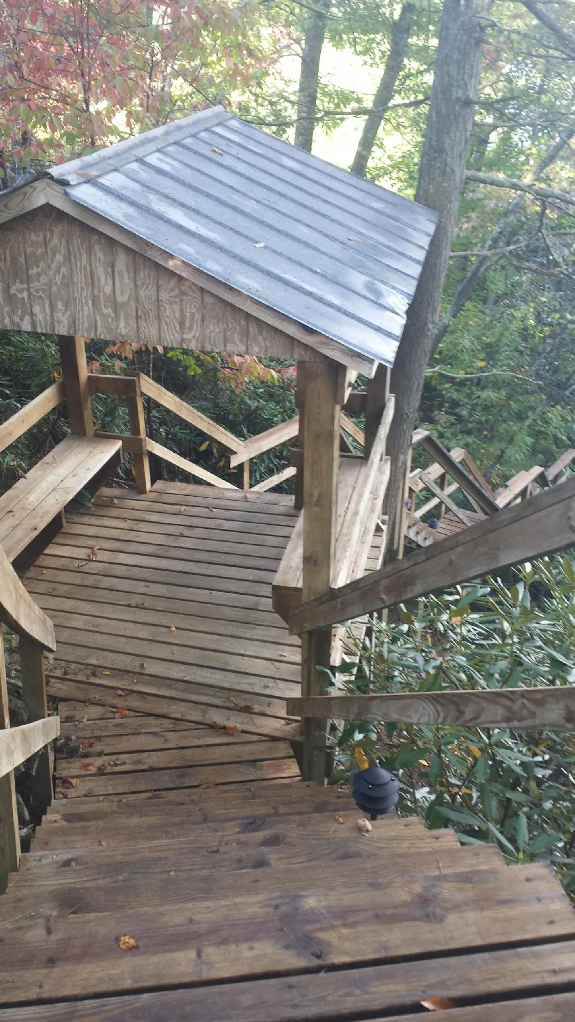 Metal roofed shelter over wooden steps on a wooded walkway — Skylight Repair & Installation work by our crew in Towanda