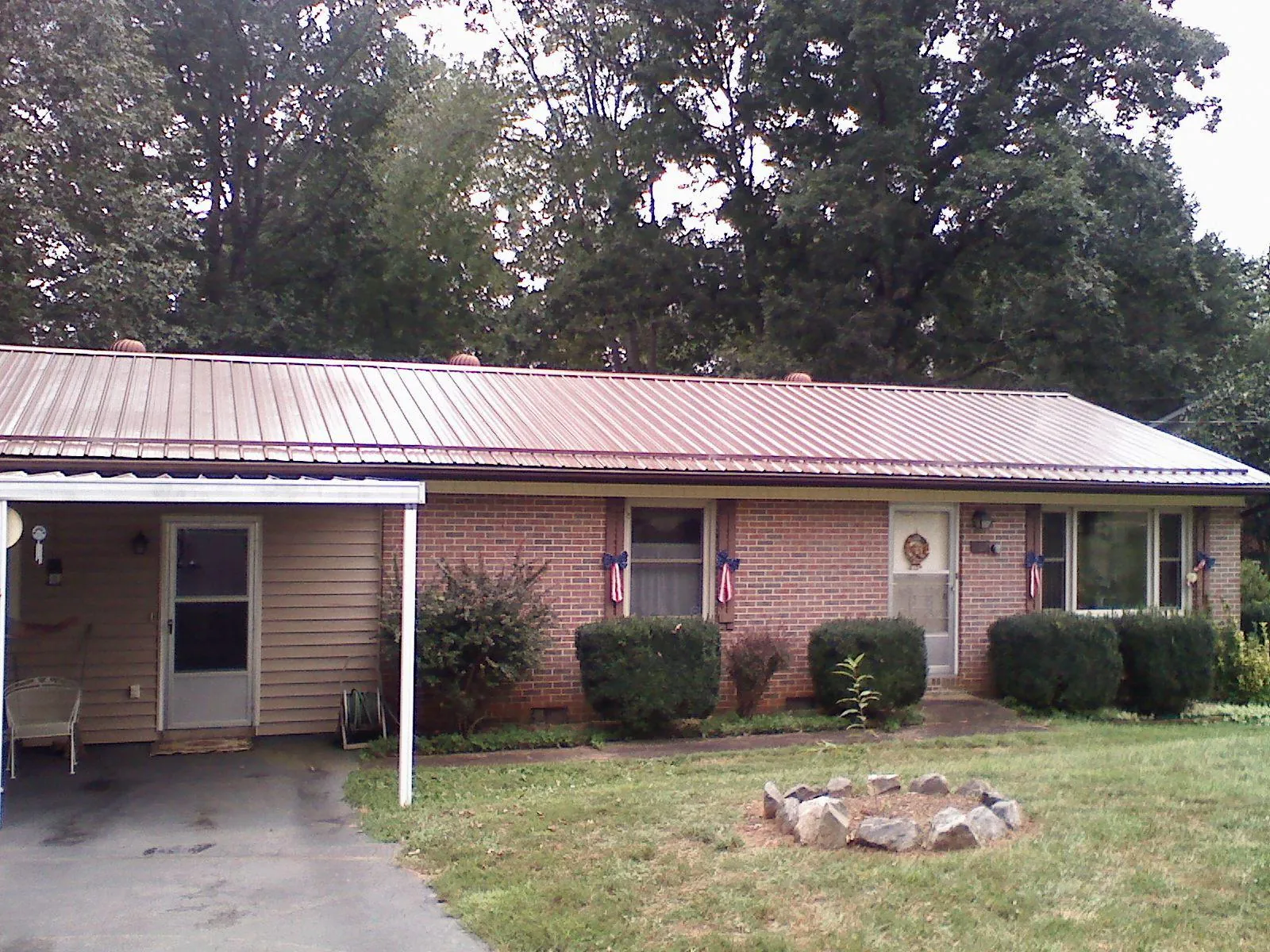 Bronze metal roof and carport on a brick ranch home — Roof Repair work by our crew in Towanda